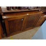 A 1.07m antique mahogany cabinet with shelves enclosed by a pair of panelled doors, set on plinth