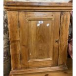 A 59cm antique waxed pine wall hanging corner cabinet with panelled door