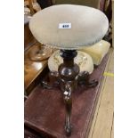 A Victorian mahogany revolving piano stool with upholstered top, set on turned pillar and tripod