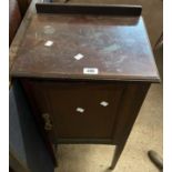 An old stained oak pot cupboard enclosed by a panelled door