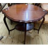 A 74cm Edwardian mahogany two tier occasional table with shaped surfaces, set on slender cabriole