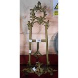 A vintage cast brass table easel with decorative Rococo styling