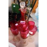 A cranberry glass claret form decanter - sold with six associated cranberry bowl wine glasses