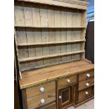 A 1.5m pine two part dresser with associated three shelf open plate rack over a Victorian base