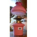A Victorian twin burner oil lamp with opaque pink glass reservoir chimney and pink satin glass