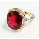 A hallmarked 750 gold ring, set with large central oval treated and filled ruby within a diamond