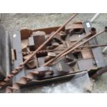 A box containing a selection of antique and other woodworking tools including planes, auger bits,
