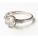 A hallmarked platinum 1.22ct. diamond solitaire ring with flanking baguette diamonds - 0.18ct -