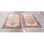 A pair of Middle Eastern handmade mats with central stylised floral motifs within double borders -