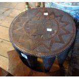 A carved wood African (Ivory Coast) tribal stool with incised geometric design to top - old damage