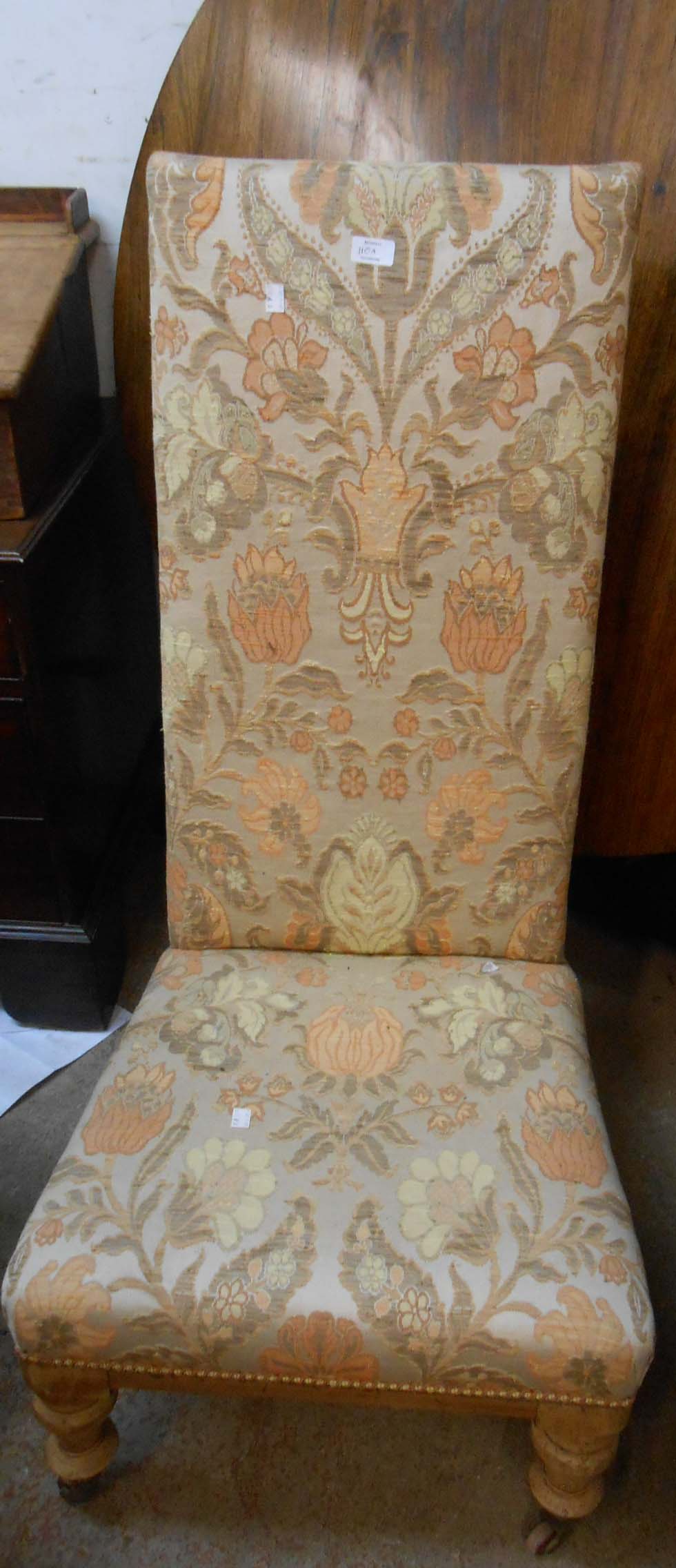 An Edwardian nursing chair with later upholstery