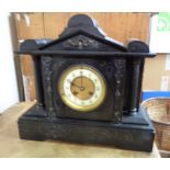 A late Victorian black slate cased mantle clock of architectural design with eight day gong striking