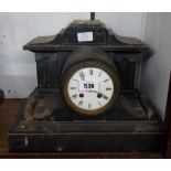 A late Victorian black slate cased drum and scroll mantle clock with eight day bell striking