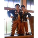 A modern resin figurine of Laurel & Hardy on a wooden stand