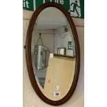An Edwardian small mahogany and strung oval framed wall mirror with bevelled plate