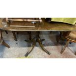 A 1.52m overall reproduction mahogany pedestal dining table with leaf, set on turned pillar and