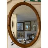 A modern pine framed bevelled oval wall mirror