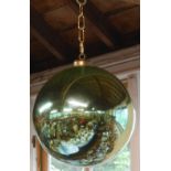 A large green mirror glass witch ball with turned wooden stand