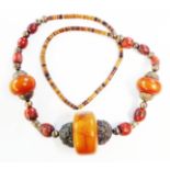 A large heavy white metal and amber bead ethic necklace with multi-coloured small amber discs and