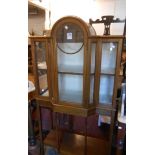 A 77cm early 20th Century walnut and strung break dome-top display cabinet with material lined