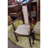 An early 20th Century stained walnut framed elbow chair with upholstered back and seat, set on