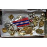 A tin containing a collection of British, German and Russian army badges, also a World War II