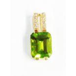 A hallmarked 585/14k gold pendant, set with large oblong peridot and tiny diamonds to suspender