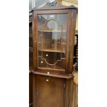 A reproduction mahogany corner cabinet with glazed top over cupboard, set on swept feet
