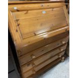 A 90cm modern polished pine bureau with part fitted interior over three long drawers, set on