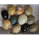 A small box containing eleven stone and wood carved eggs