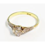 A marked 18ct. vintage diamond solitaire ring with diamond set shoulders
