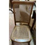 An old stained beech framed standard chair with rattan back and seat panels, set on turned front
