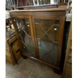 A 92cm 20th Century mahogany display cabinet with glass shelves enclosed by a pair of astragal