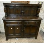 A 1.2m modern polished oak court cupboard with panelled doors and flanking turned supports to top