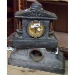 A late Victorian black slate cased mantle clock of architectural design with eight day gong striking