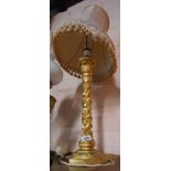 A carved giltwood table lamp of column form with fruiting spirals and acanthus terminal