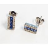 A pair of high carat white metal oblong panel ear-rings with central channel set sapphires and