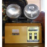 A vintage Starking brand emergency light with two large directional spotlights above a battery case