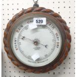 A late 19th Century oak cased wall barometer with rope twist border and printed ceramic dial