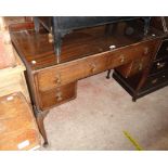 A 1.06m 20th Century mahogany kneehole dressing table with glass top and four drawers, set on