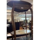 An Edwardian polished oak two tier occasional table, set on slender cabriole supports