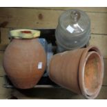 An old wooden storage box containing assorted items including vintage sweet jar, terracotta flower