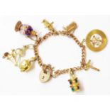A 375/9ct rose metal charm bracelet with marked 750 and other yellow metal charms including spinner,