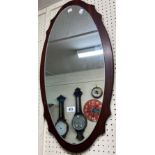 A retro style stained wood mounted oval wall mirror