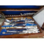 A vintage walnut canteen containing a quantity of ornate silver plated cutlery