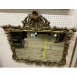 A vintage Rococo style gilt framed wall mirror with ornate pediment and shaped plate - minor loss