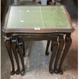 A nest of three reproduction mahogany tea tables with glass inset tops