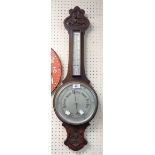 An early 20th Century carved oak cased banjo barometer/thermometer with aneroid works