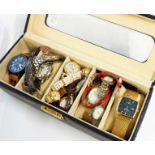 An upholstered case containing a collection of assorted modern wristwatches