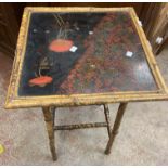 An antique bamboo occasional table with decorative lacquered surface and double stretchers under -